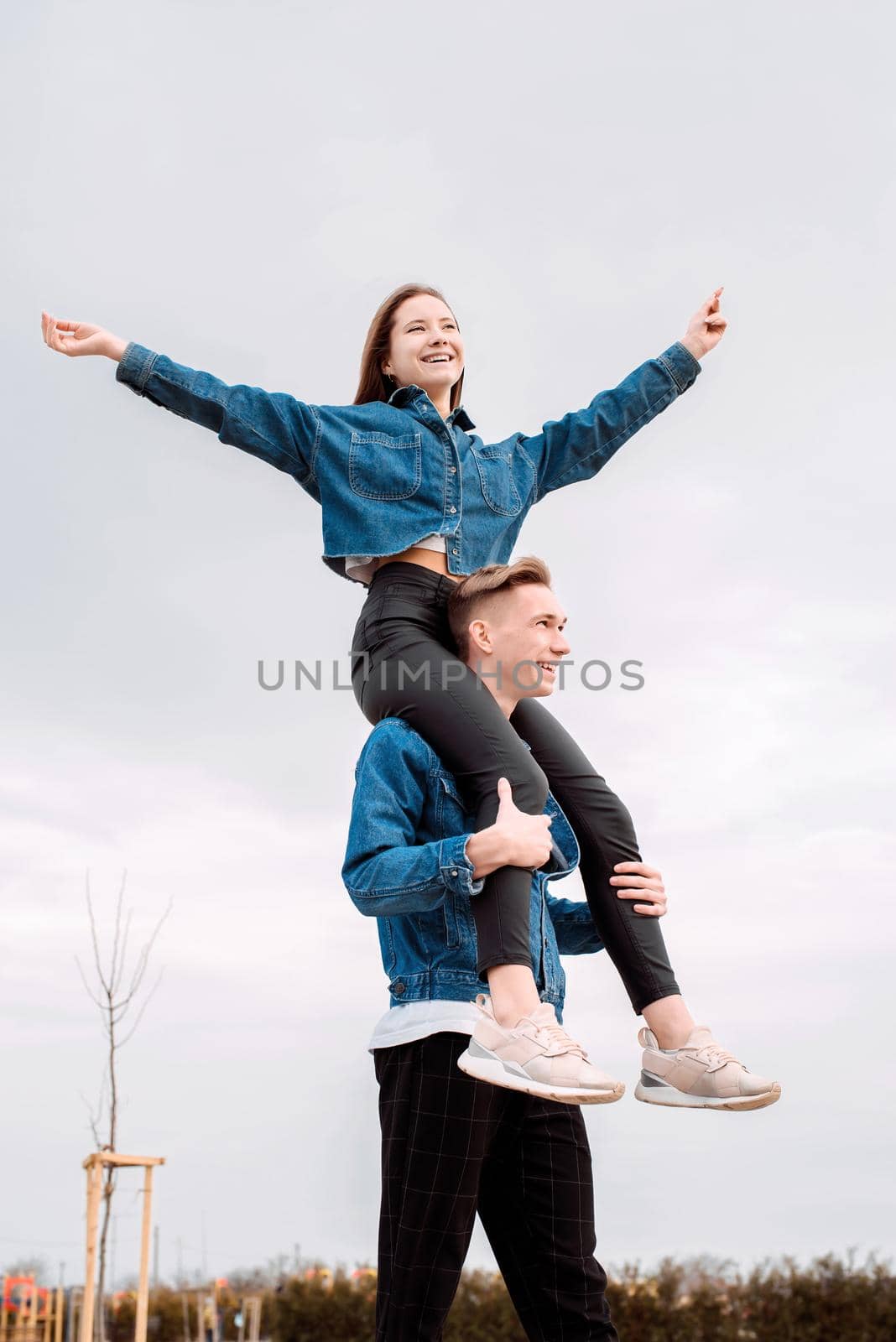 Young loving couple wearing jeans spending time together in the park having fun