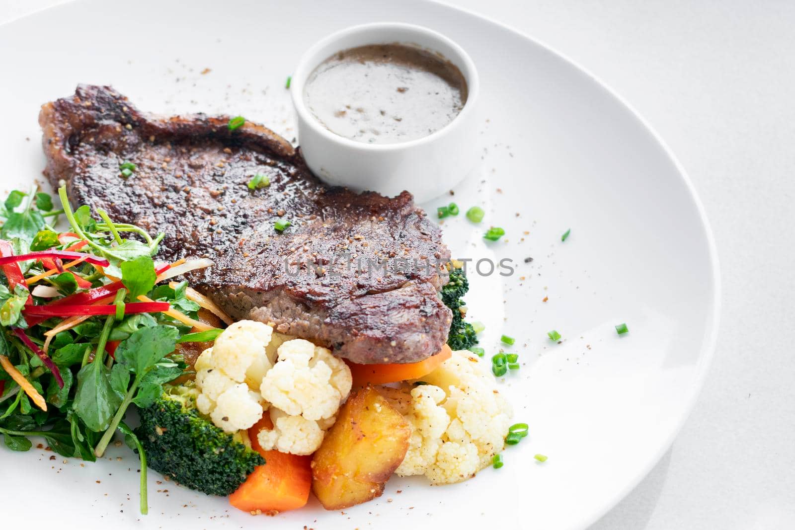 premium beef steak with steamed vegetables and mushroom sauce gourmet meal on white plate