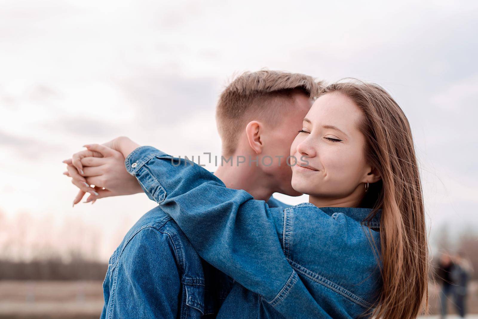 Happy young loving couple embracing each other outdoors in the park having fun
