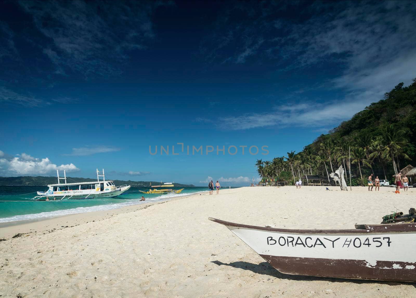 tourist boats on puka beach in tropical boracay island philippines by jackmalipan