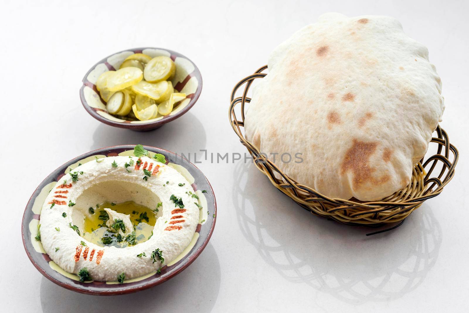 bowl of fresh organic hummus lebanese food  on white table by jackmalipan