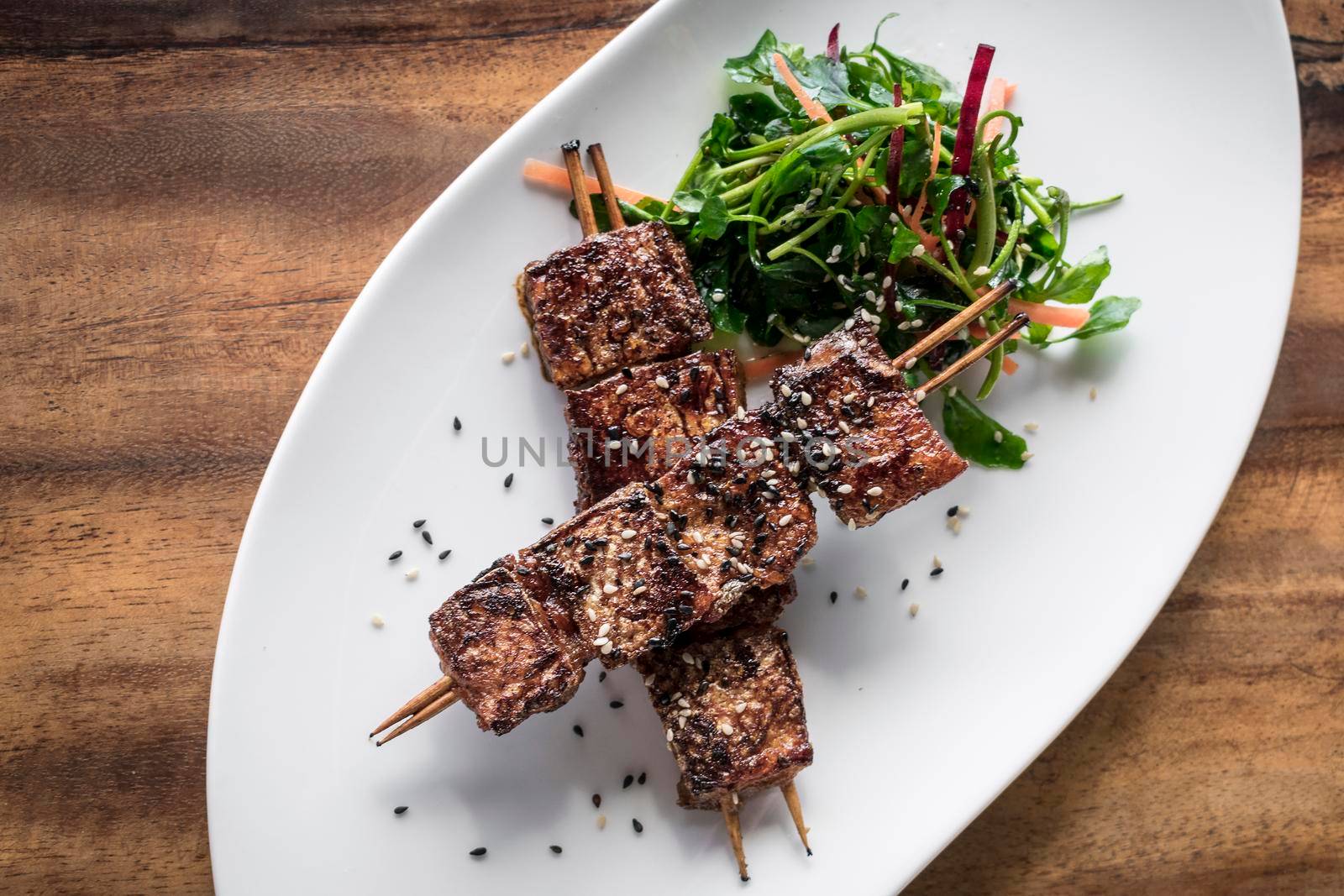 asian spicy sweet soy sauce and sesame seed grilled barbecue pork skewers in singapore restaurant