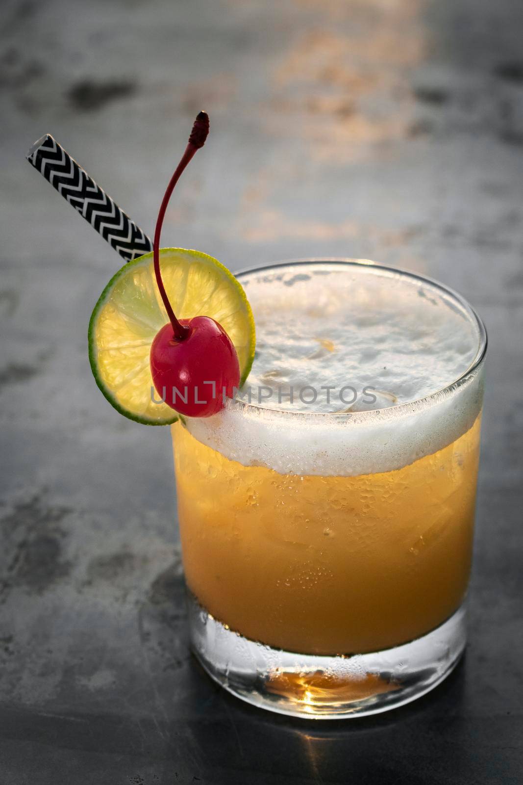 peach screwdriver mixed vodka cocktail drink outdoors at sunset bar