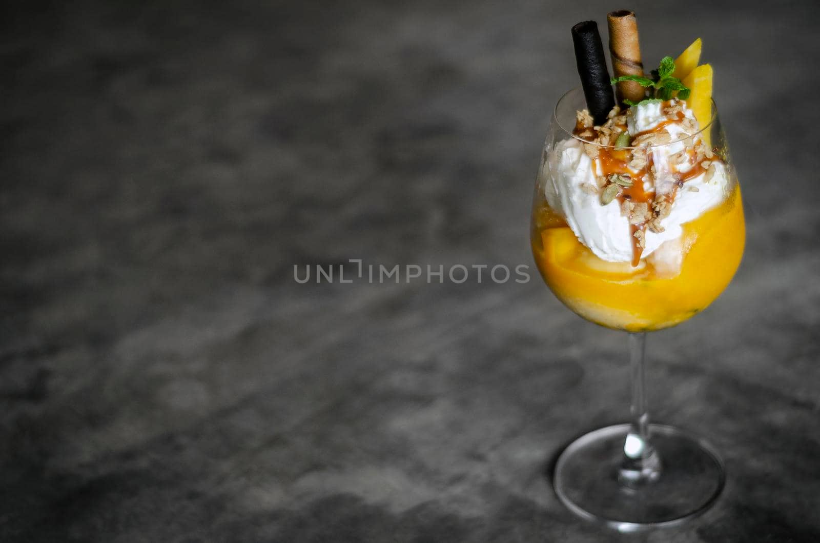 mango and passion fruit tropical ice cream sundae in glass by jackmalipan