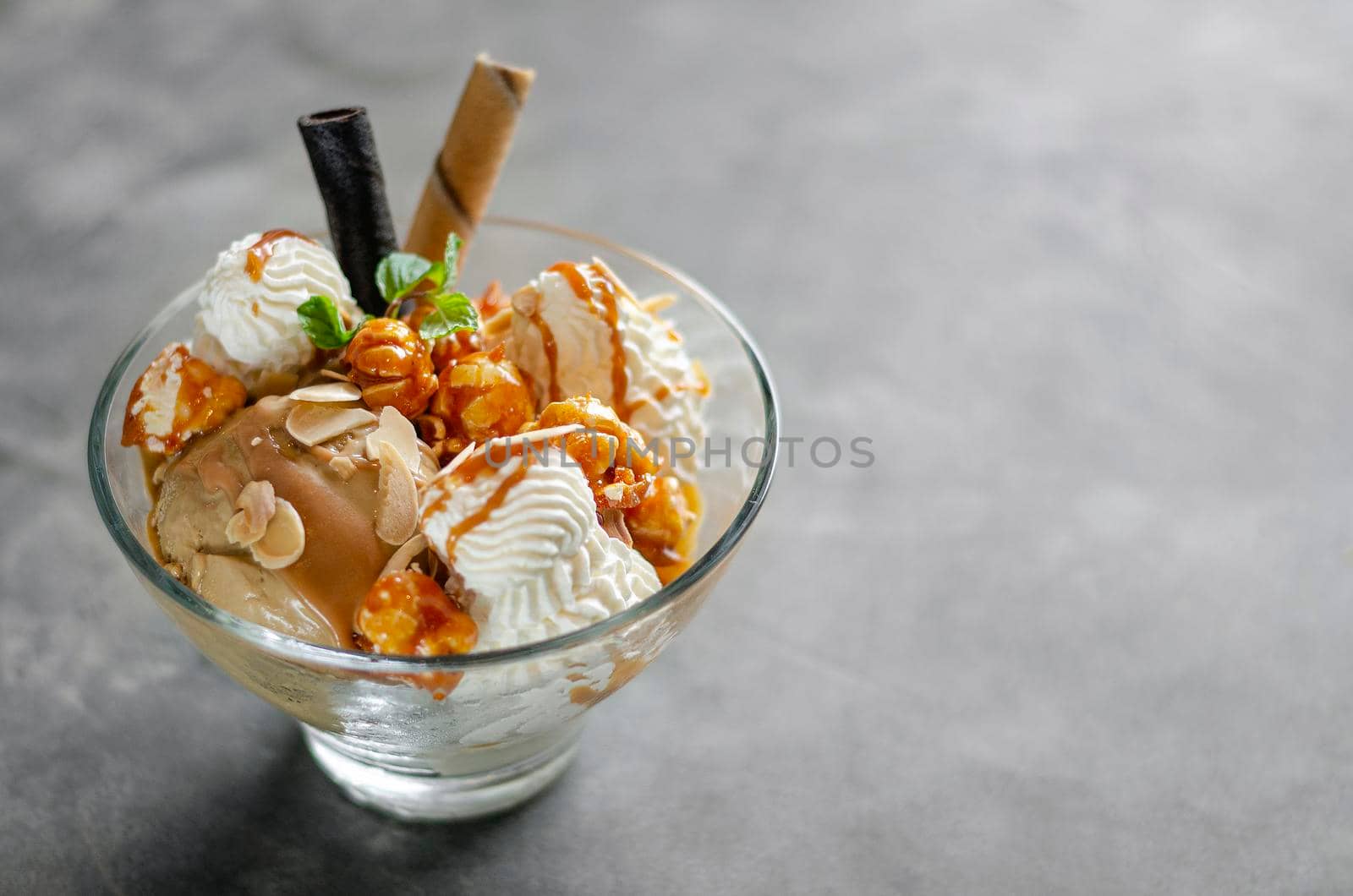 caramel and almond ice cream with caramelized popcorn sundae dessert in glass bowl