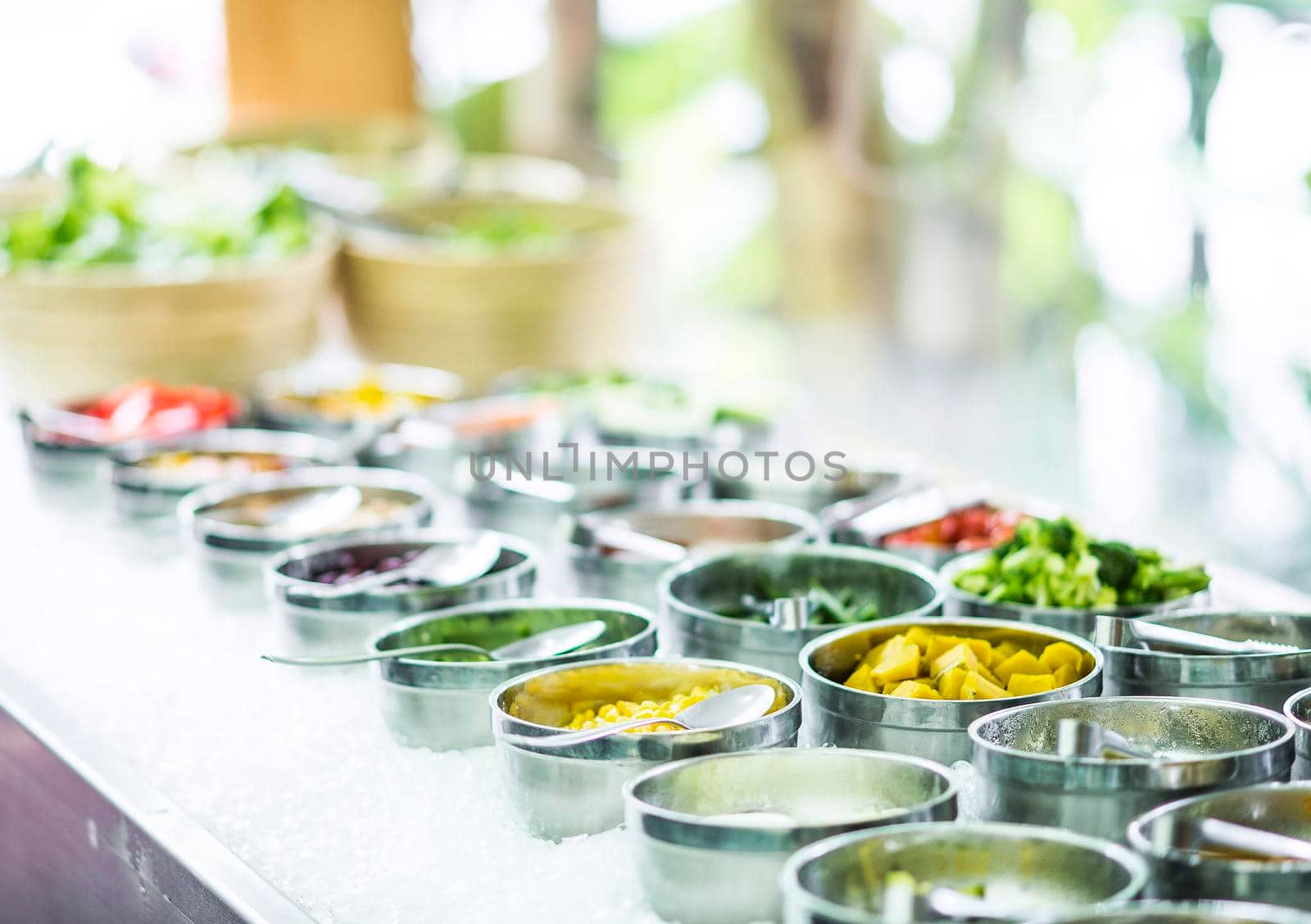 bowls of mixed fresh organic vegetables in modern salad bar display