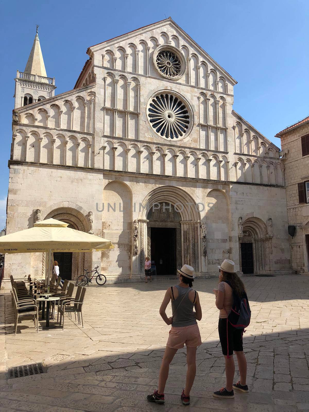 Two tourists looking at the Saint Anastasia romanesque cathedral in Zadar Croatia