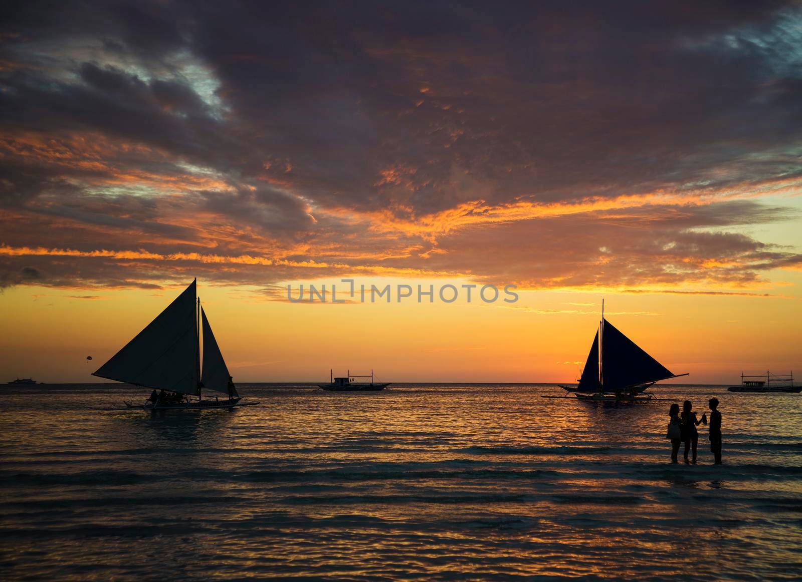 sunset and sailing boats on tropical white beach in boracay philippines by jackmalipan