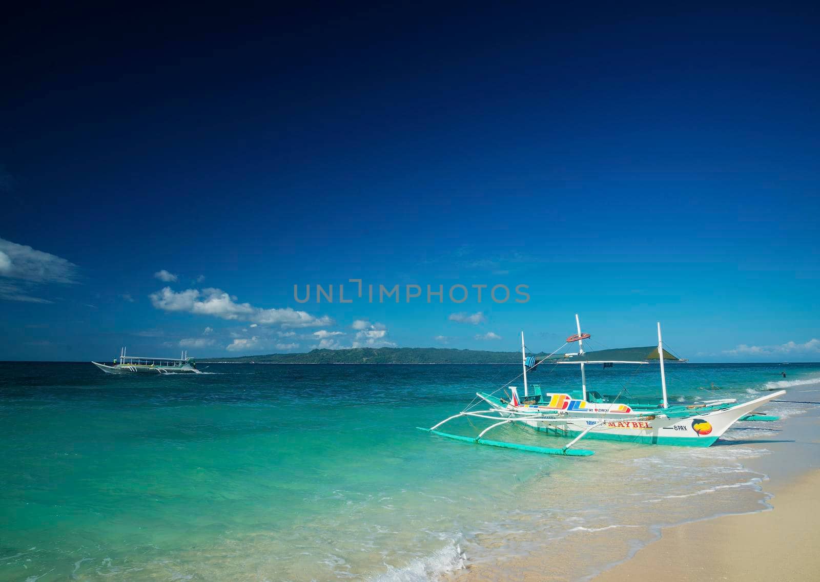 traditional boats on puka beach in boracay philippines by jackmalipan