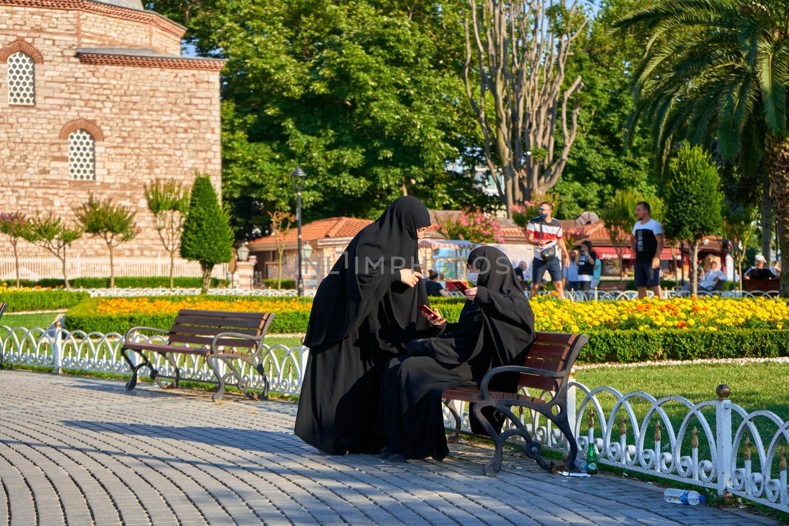 Two muslim women in hijab relaxing on the bench next to Sofia mosque.