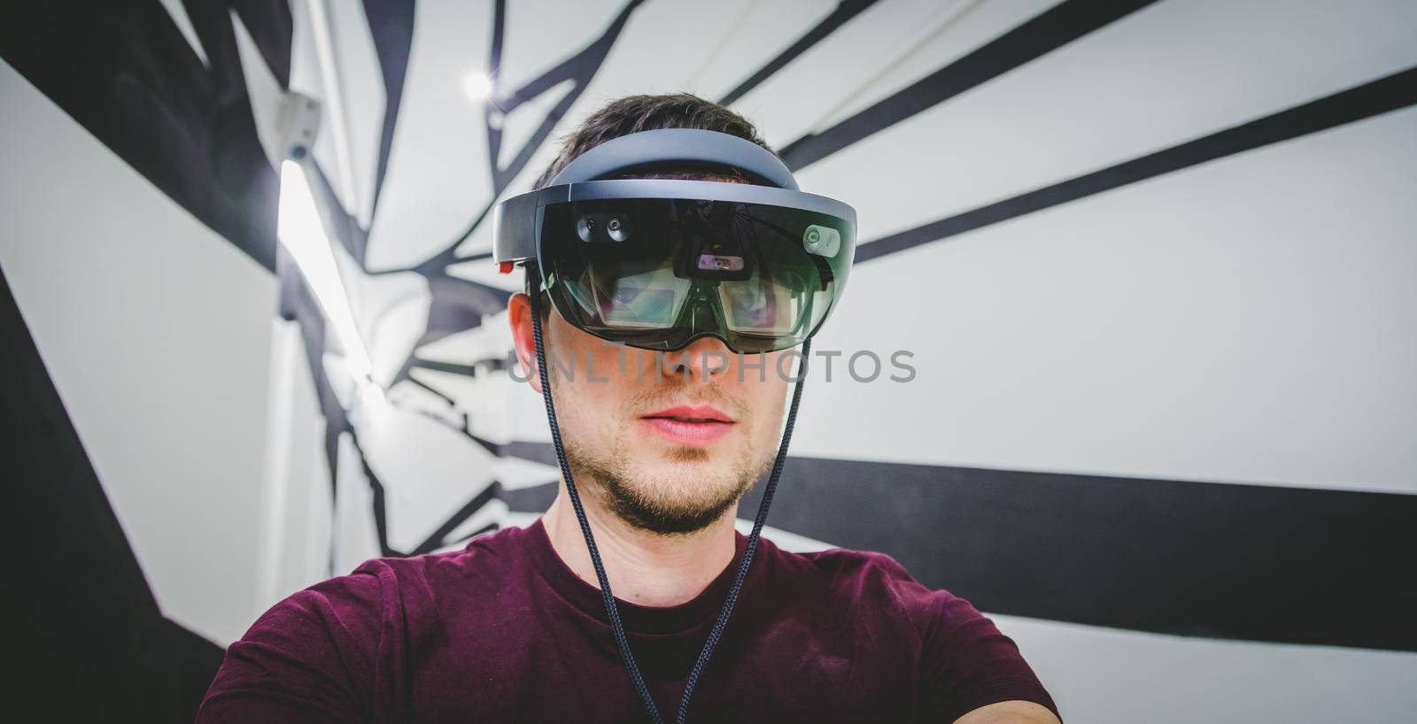 Young man wearing high end virtual reality glasses. Concept for VR, future, gadgets and technology. by Daxenbichler