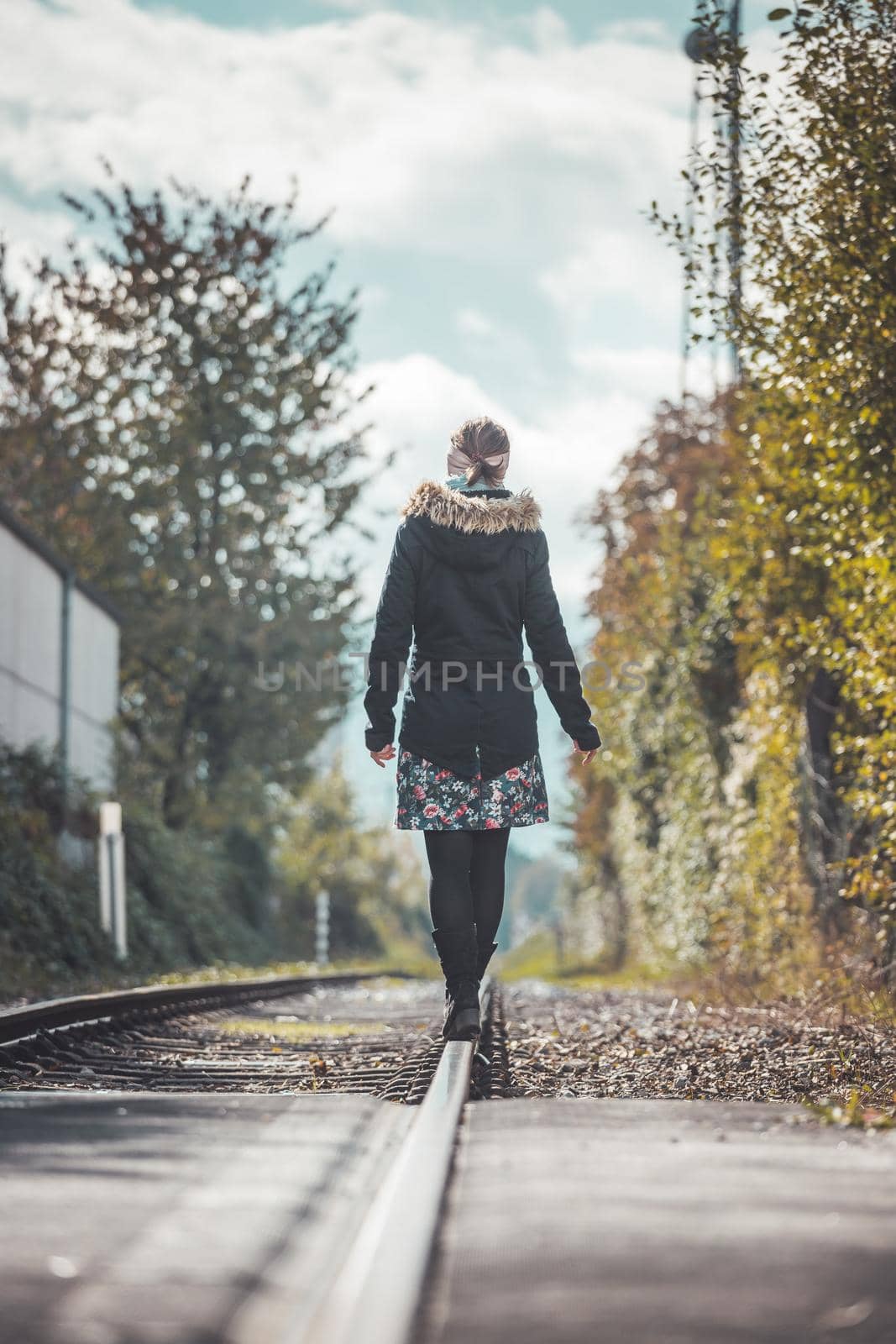 Girl waking on abandoned railroad, autumn