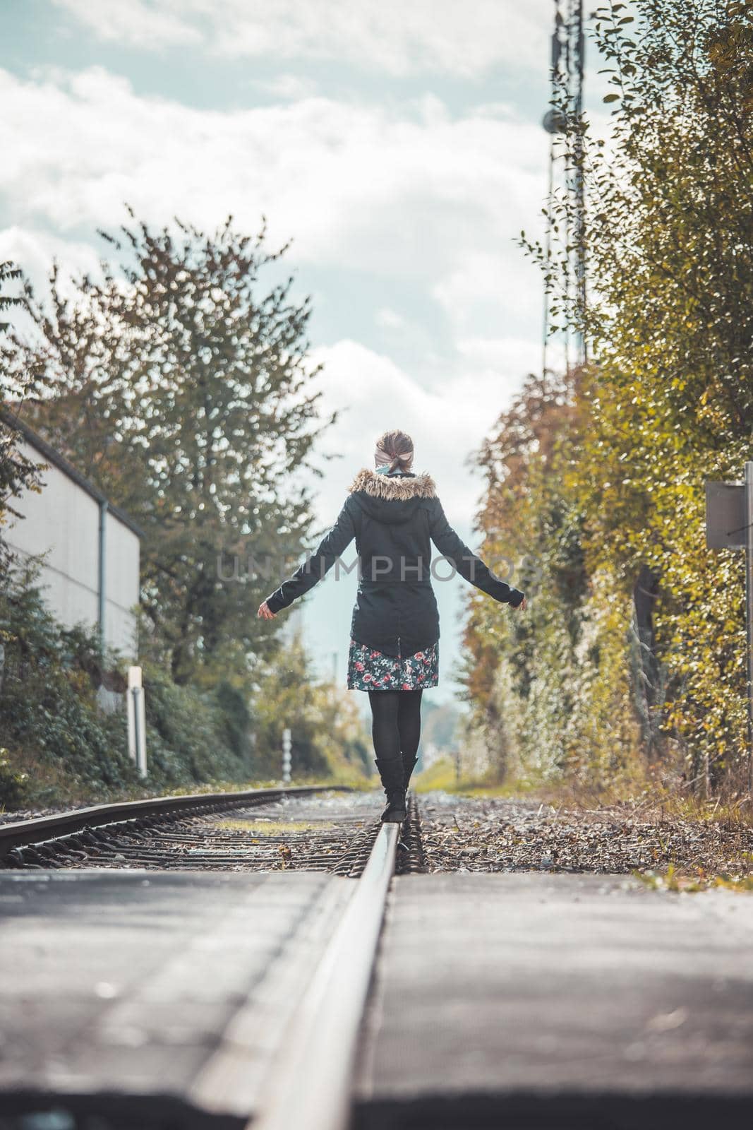 Girl waking on abandoned railroad, autumn