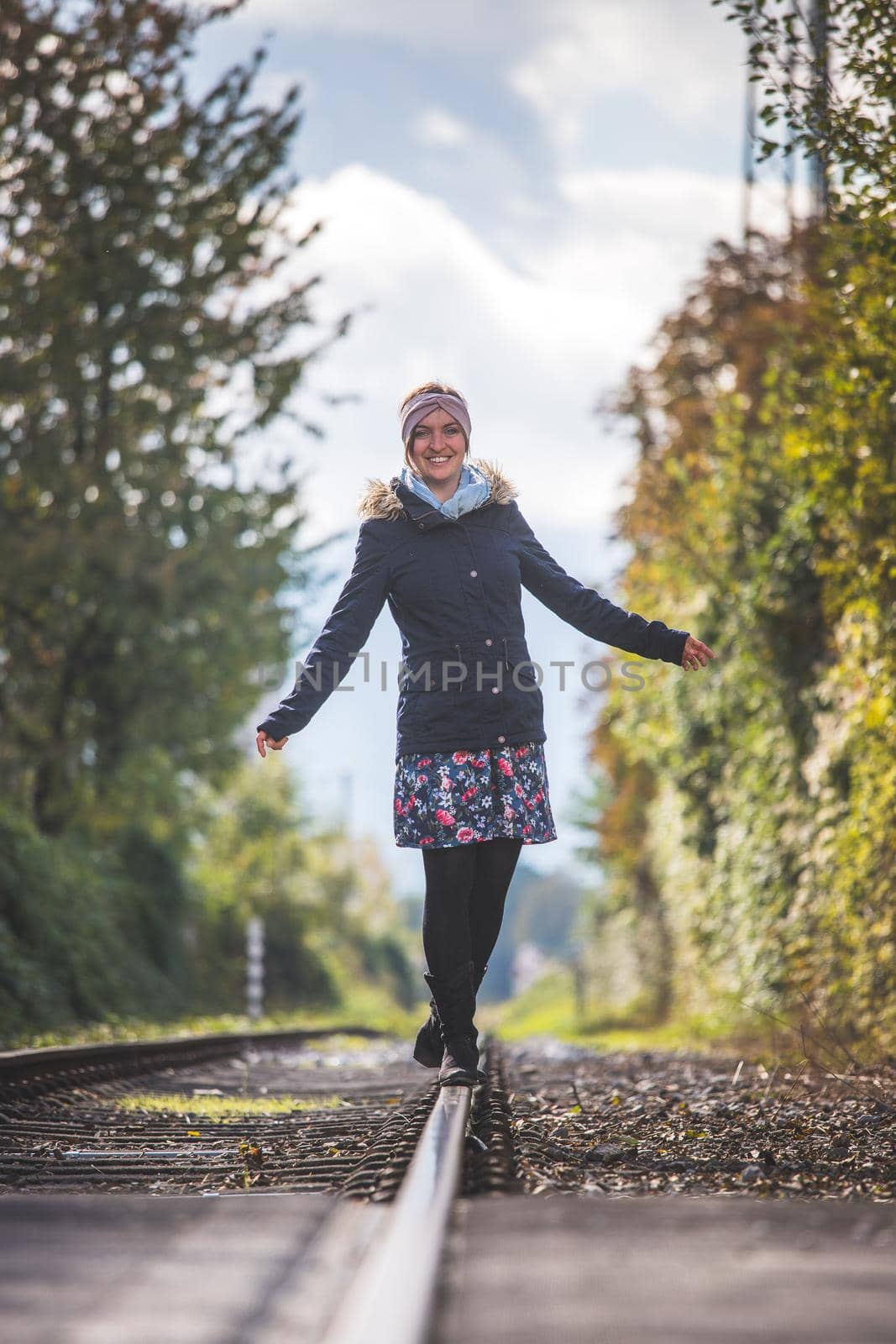 Girl waking on abandoned railroad, autumn