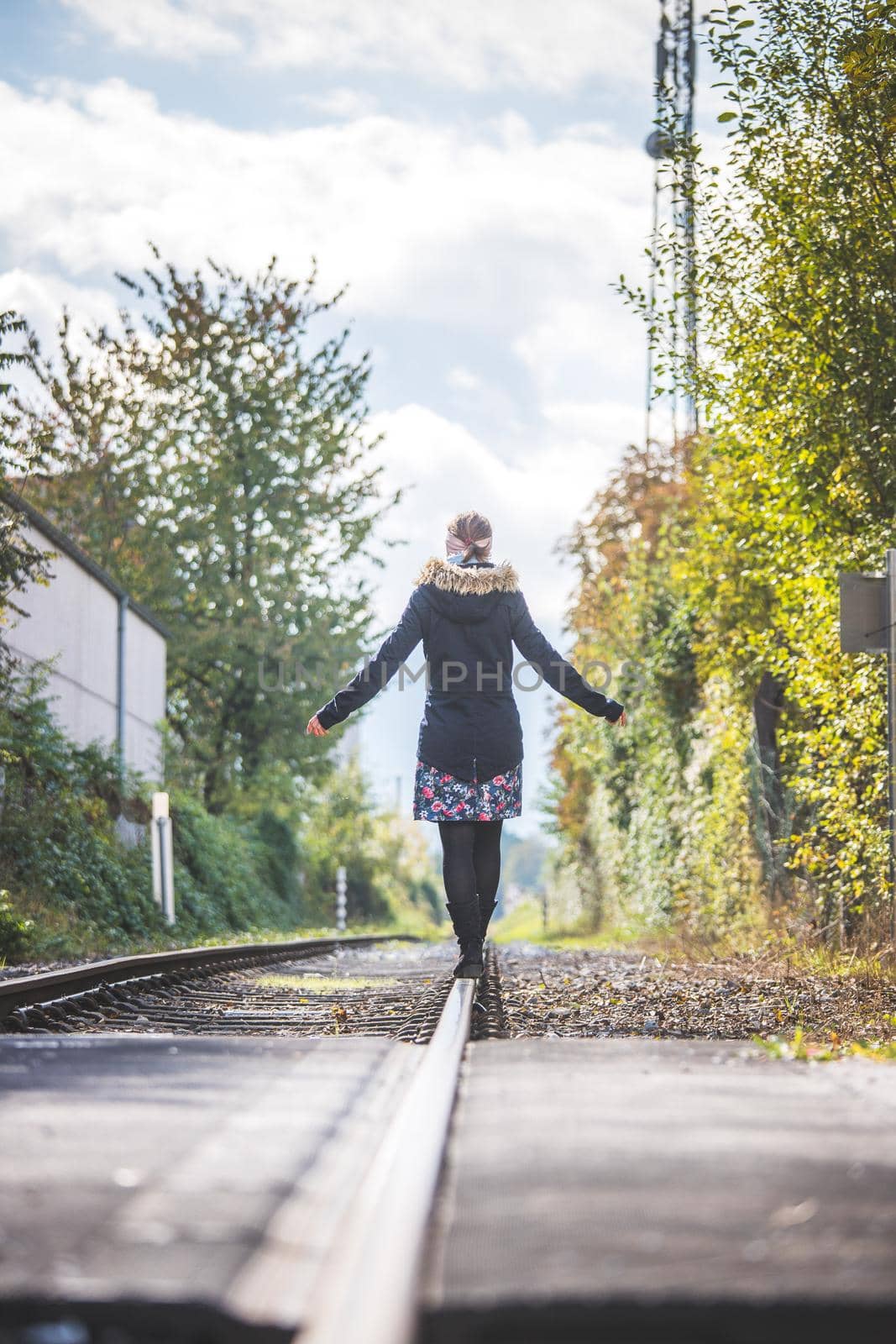 Girl waking on abandoned railroad, autumn