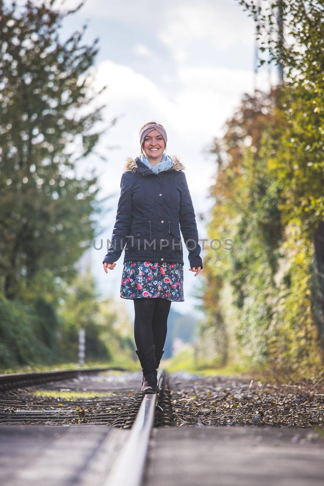 Girl waking on abandoned railroad, autumn