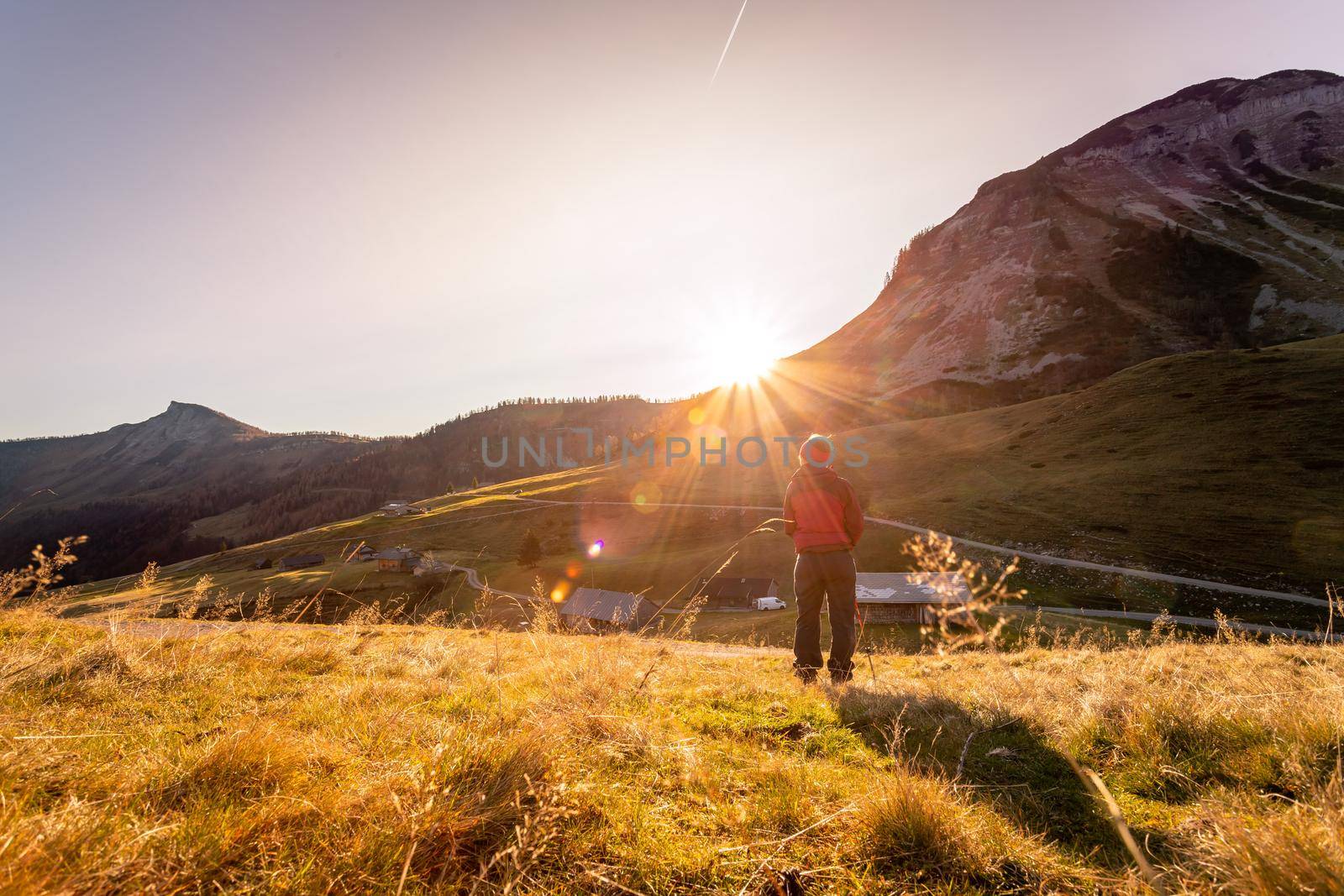 Woman in sportswear is enjoying the sunset in the mountains: sitting on the ground and enjoying the view. Alpes, Austria