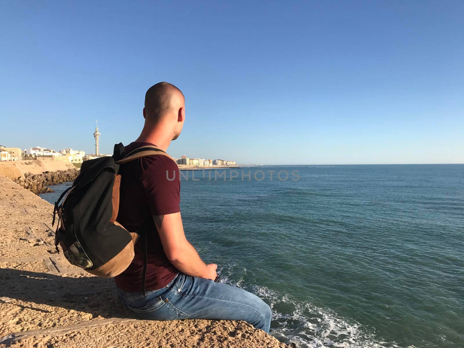 Guy looking over the Bay of Cadiz by traveltelly