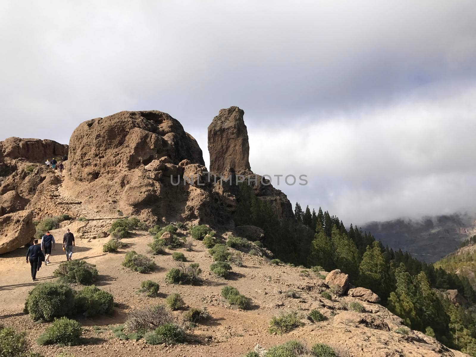 Tourist walking towards the Roque Nublo a volcanic rock on the island of Gran Canaria