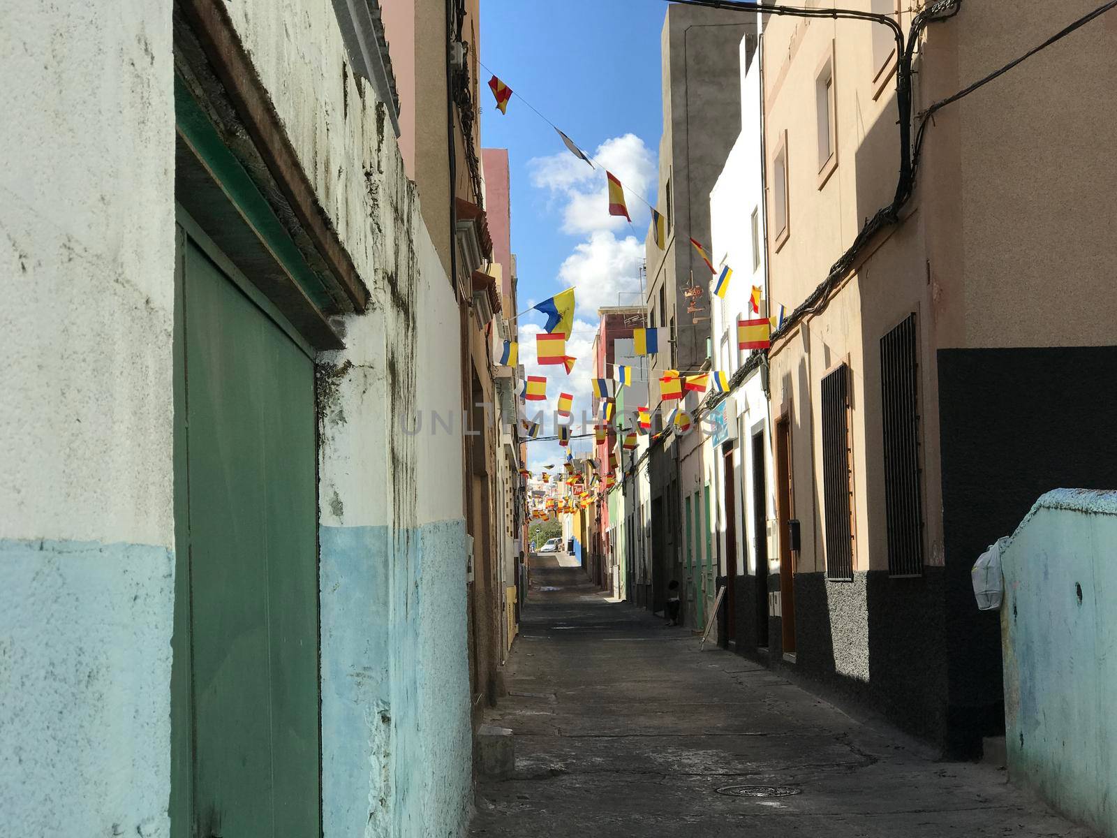 Flags in a street of Las Palmas by traveltelly