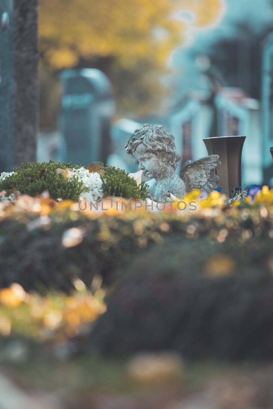 White angel on a grave at a cemetery, flowers