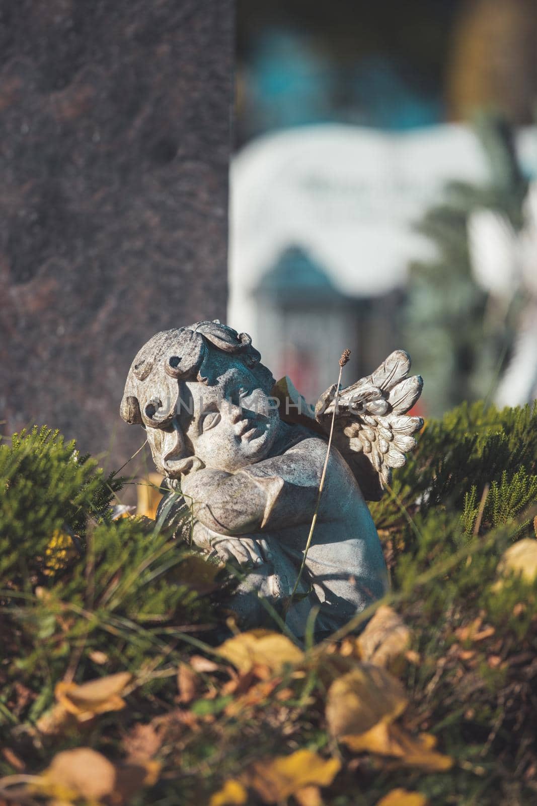 White angel on a grave at a cemetery, flowers