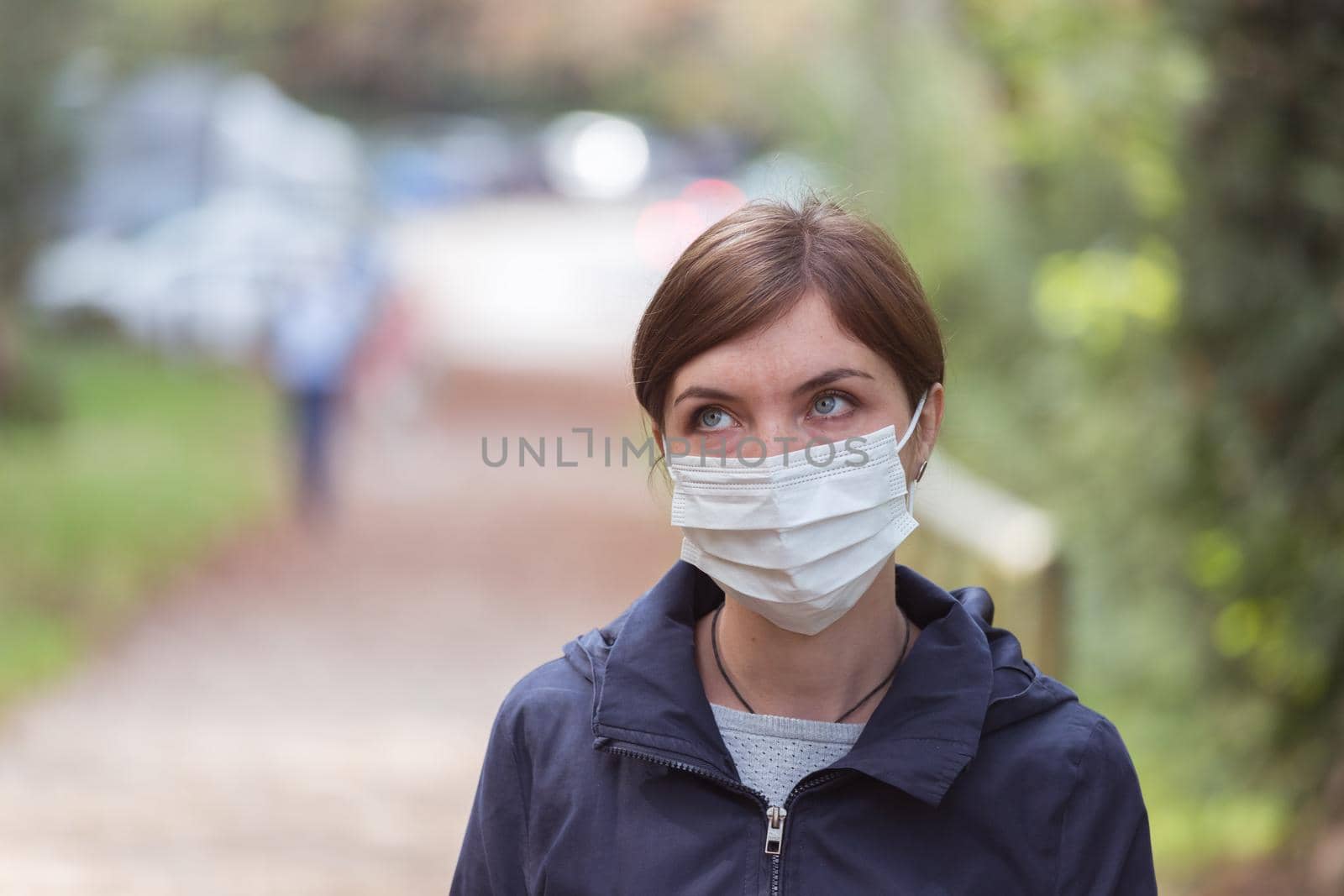 Young woman outdoors wearing a face mask. Corona and flu season.