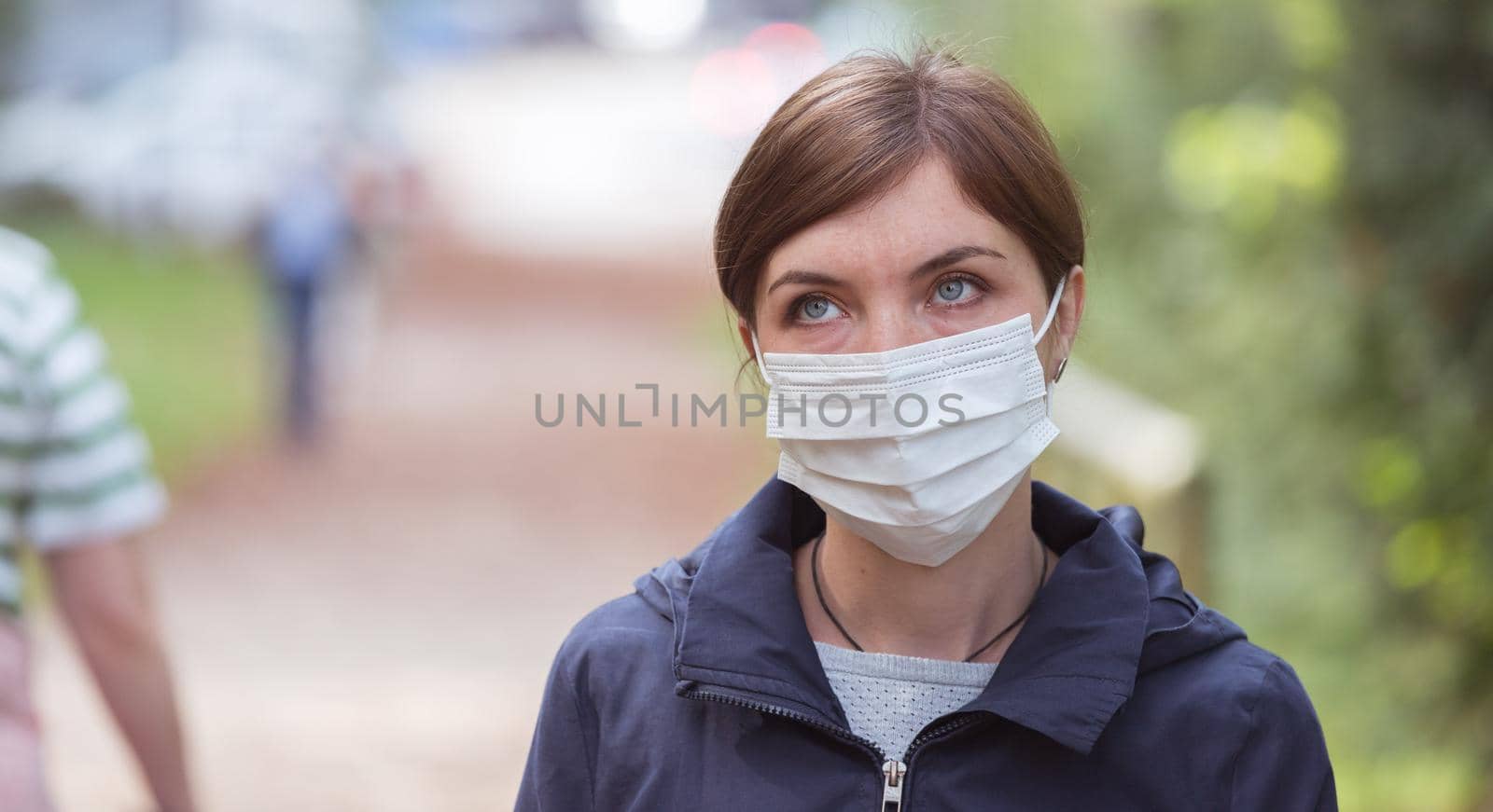 Flue and corona safety concept. Woman wearing face mask to protect herself, outdoors by Daxenbichler