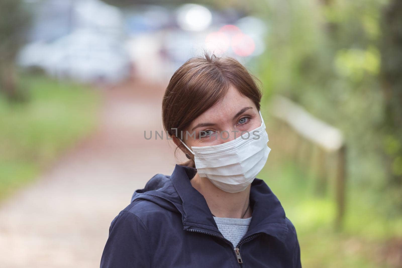 Young woman outdoors wearing a face mask. Corona and flu season.