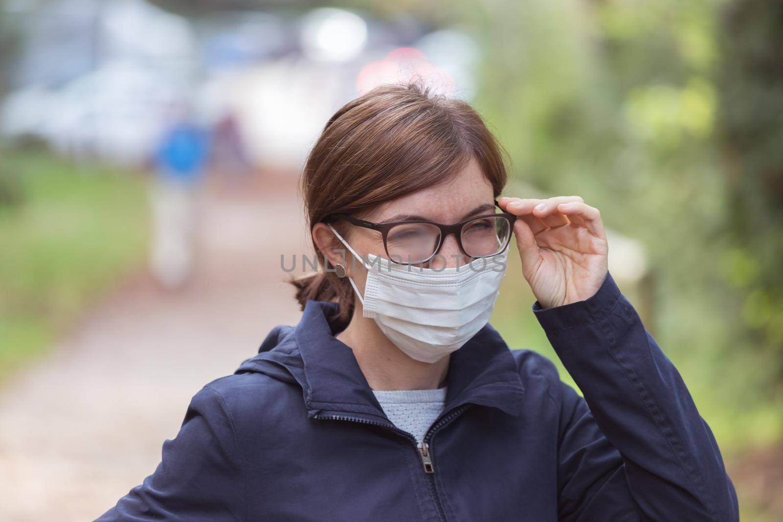 Young woman outdoors wearing a face mask and glasses, tarnished glasses