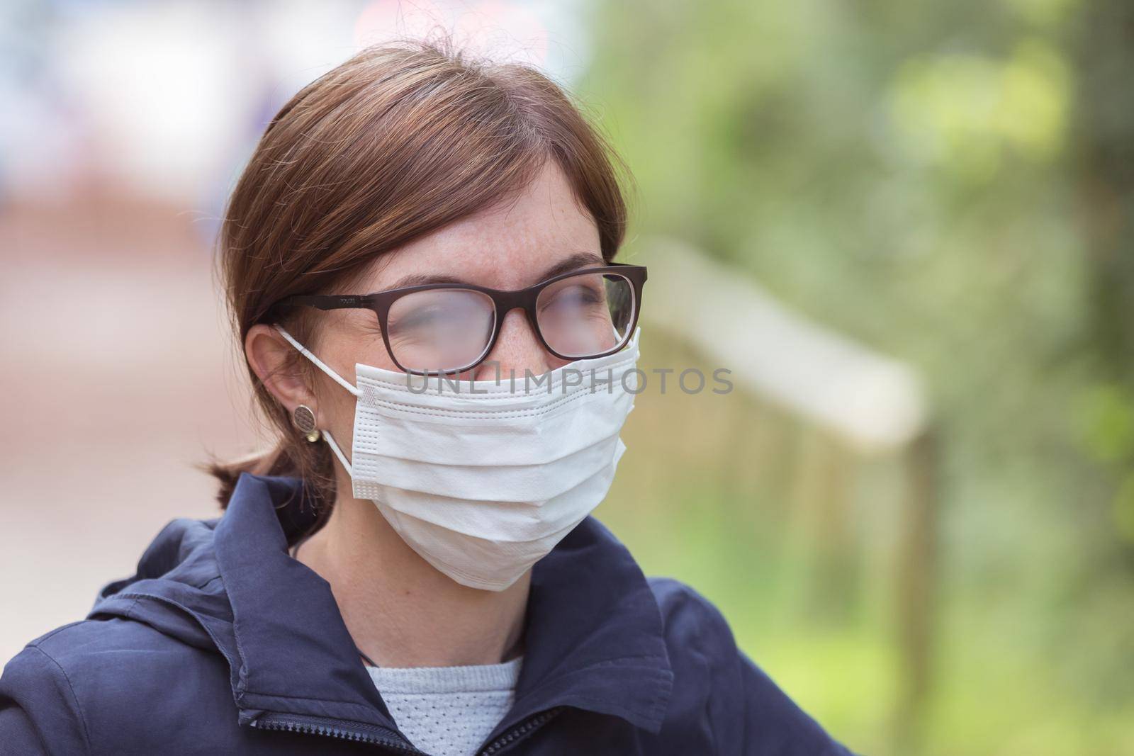 Young woman outdoors wearing a face mask and glasses, tarnished glasses