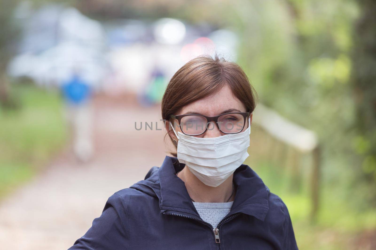 Young woman outdoors wearing a face mask and glasses, tarnished glasses