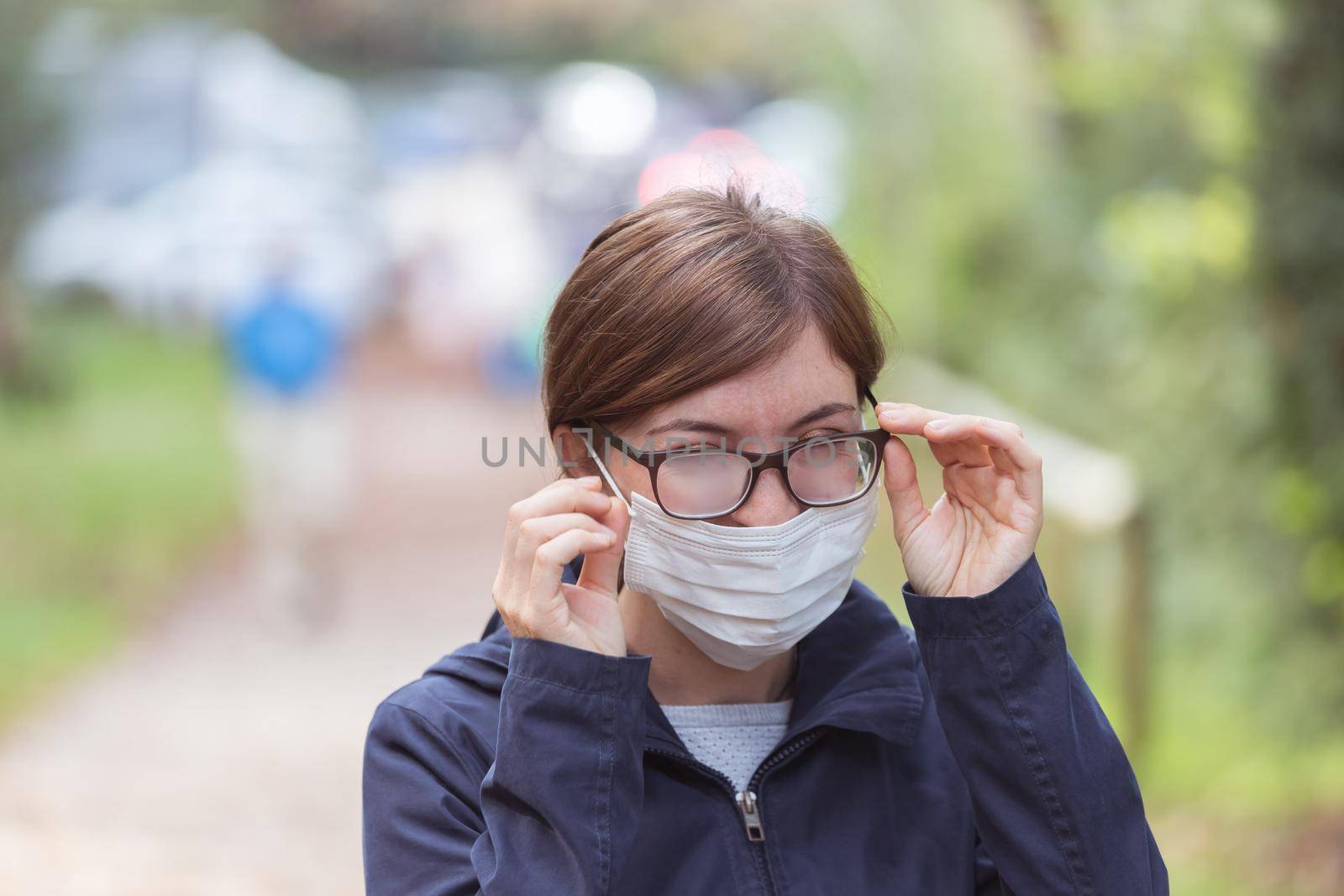 Young woman outdoors wearing a face mask and glasses, tarnished glasses