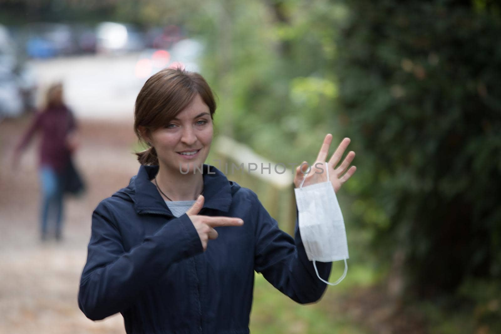 Flue and corona safety concept. Woman holding single use face mask, outdoors by Daxenbichler