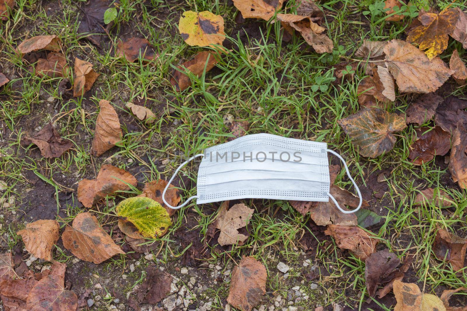Environmental pollution concept: Single use face mask on the floor outdoors, waste