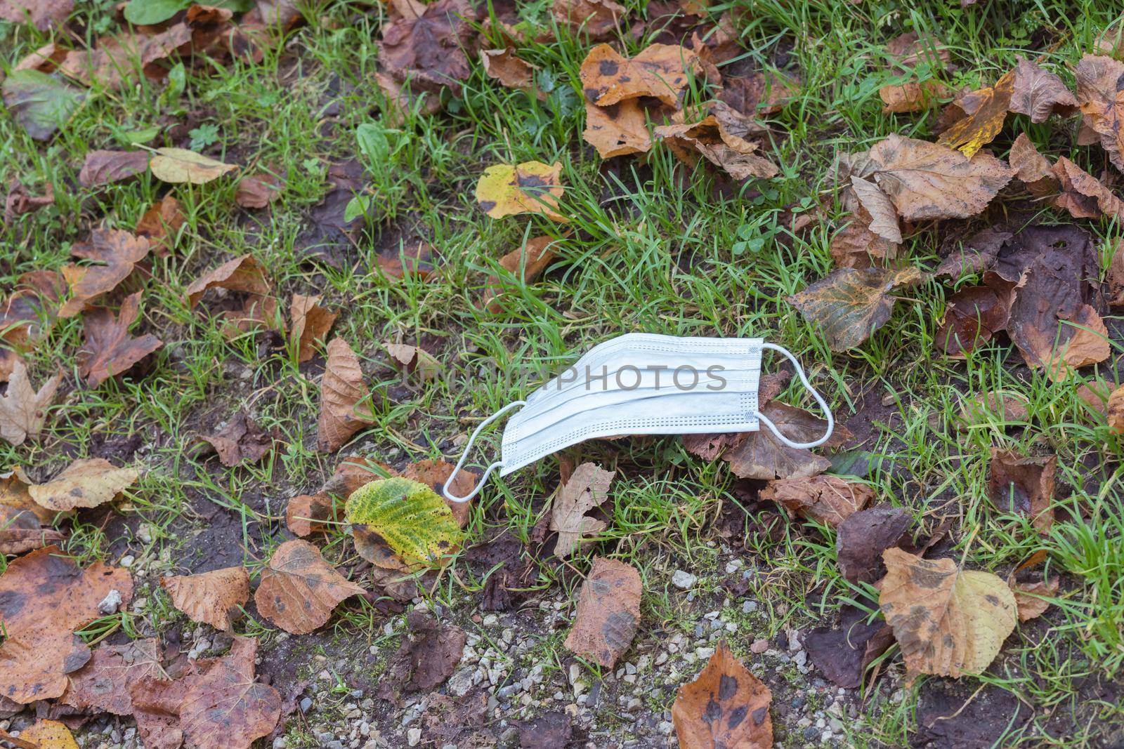 Environmental pollution concept: Single use face mask on the floor outdoors, waste