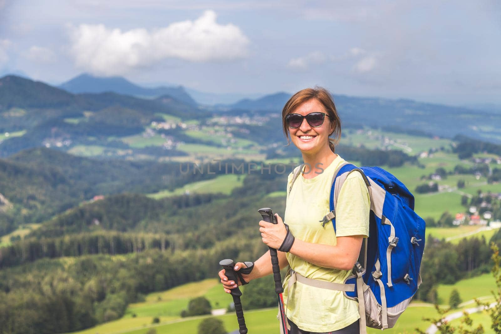 Young slim backpacker tourist girl is enjoying the view on rocky mountain, Austria
