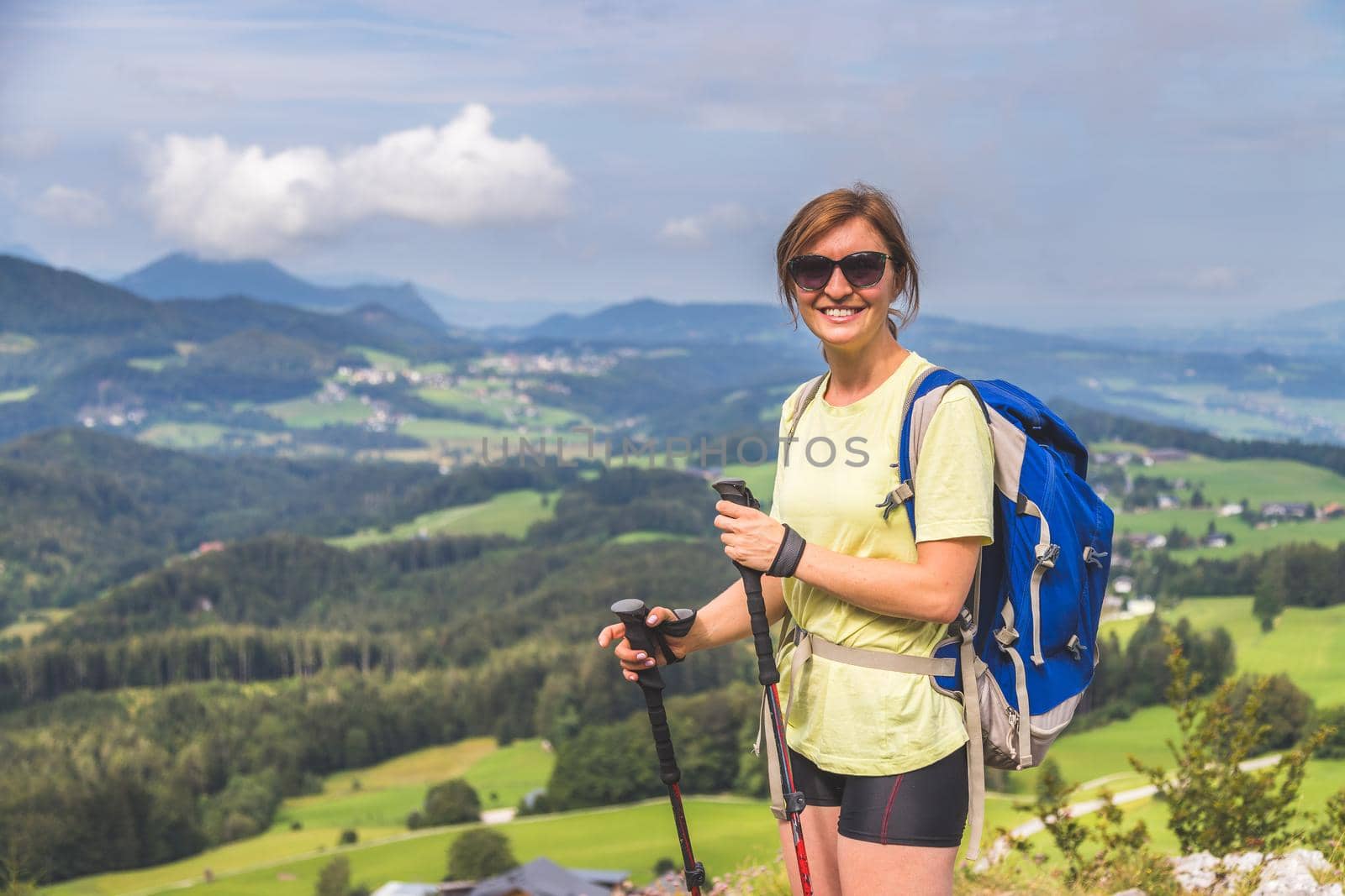 Young slim backpacker tourist girl is enjoying the view on rocky mountain, Austria