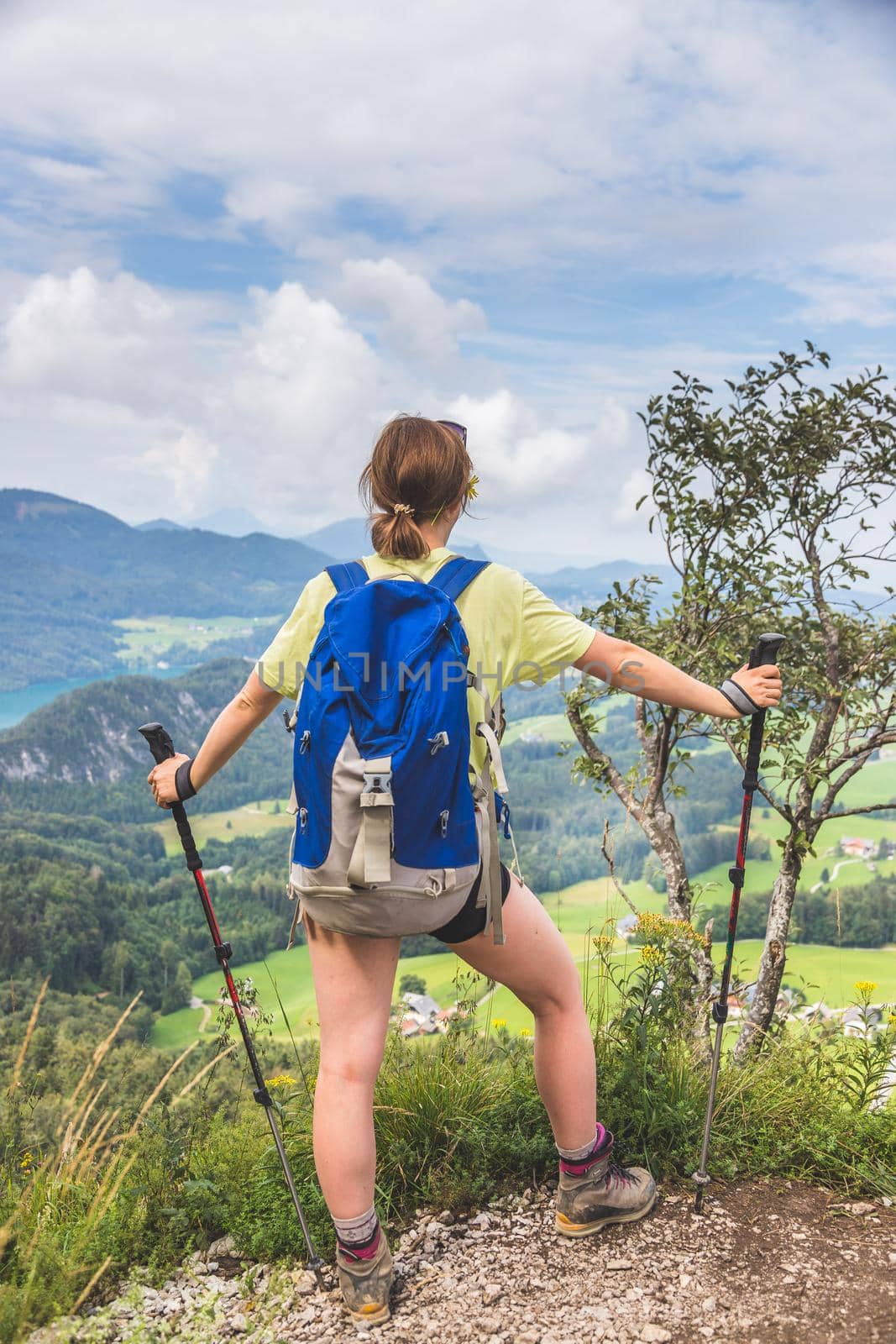 Young slim backpacker tourist girl is enjoying the view on rocky mountain, Austria