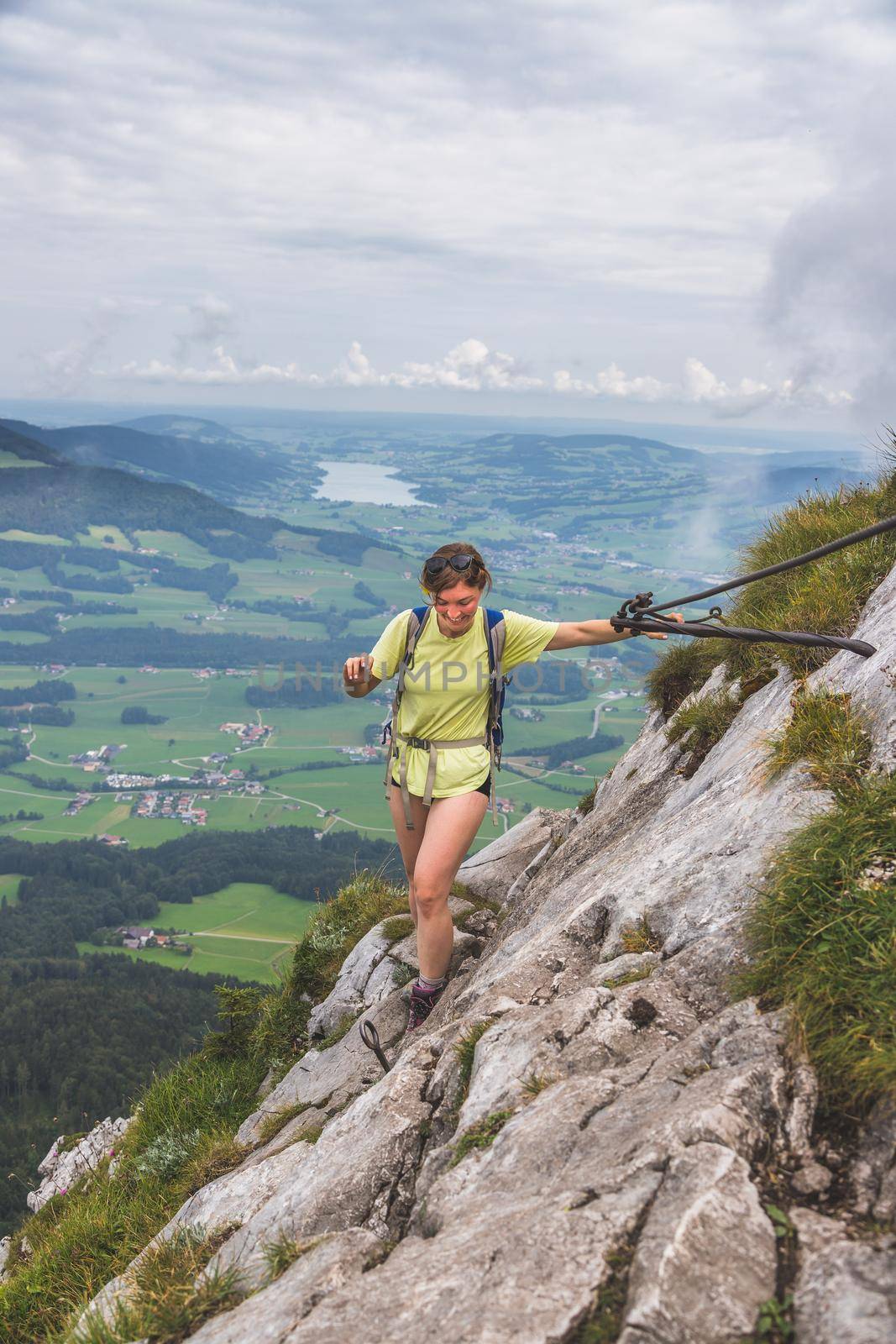 Adventure in the mountains. Young tourist girl is climbing on rocky mountain in Austria by Daxenbichler