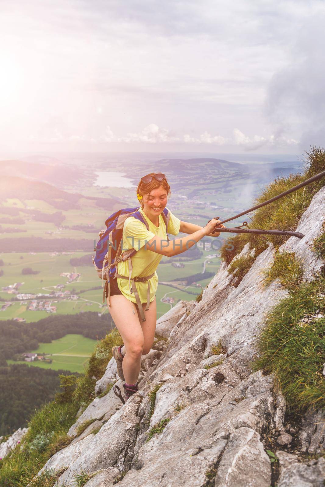 Adventure in the mountains. Young tourist girl is climbing on rocky mountain in Austria by Daxenbichler