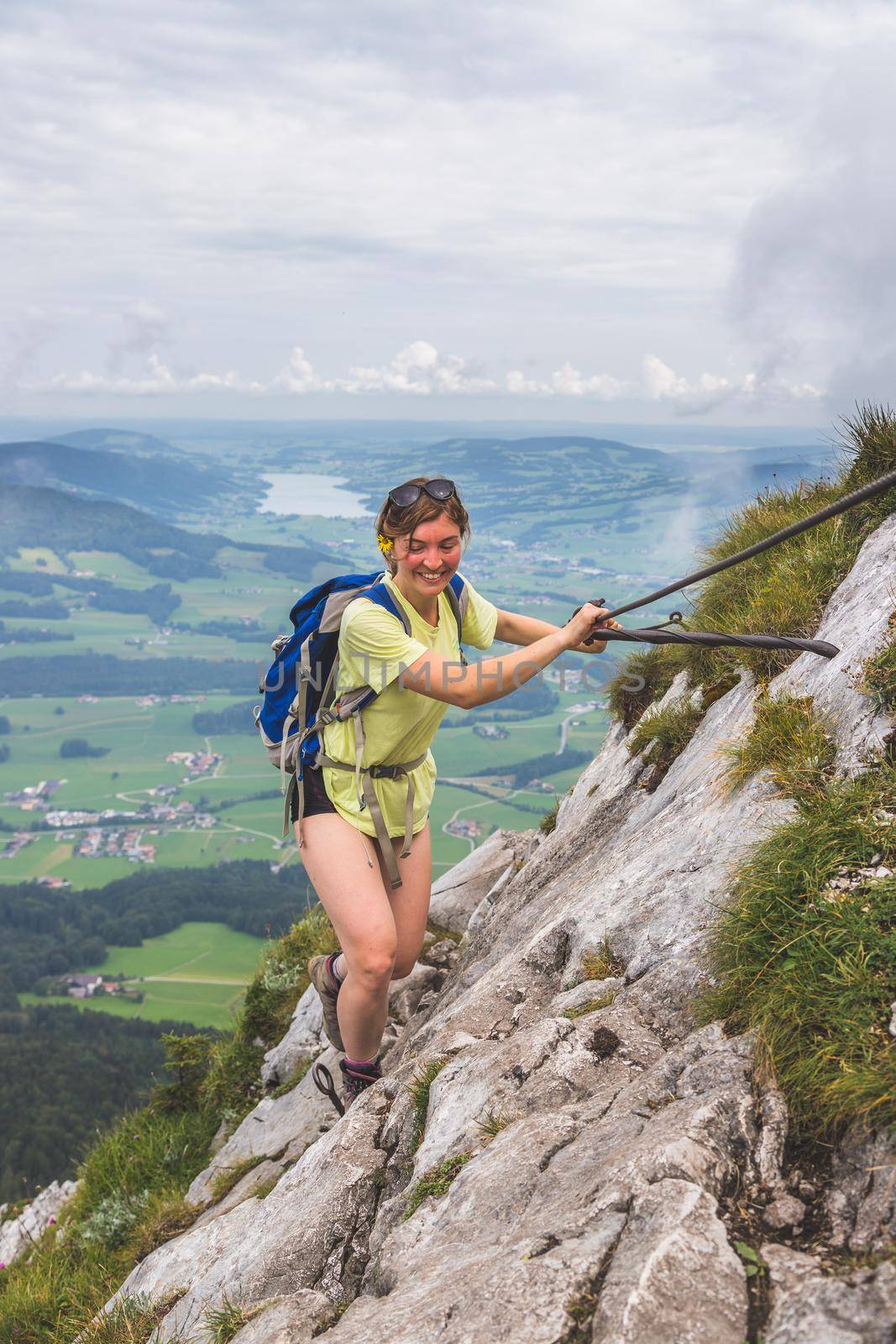 Adventure in the mountains. Young tourist girl is climbing on rocky mountain in Austria by Daxenbichler