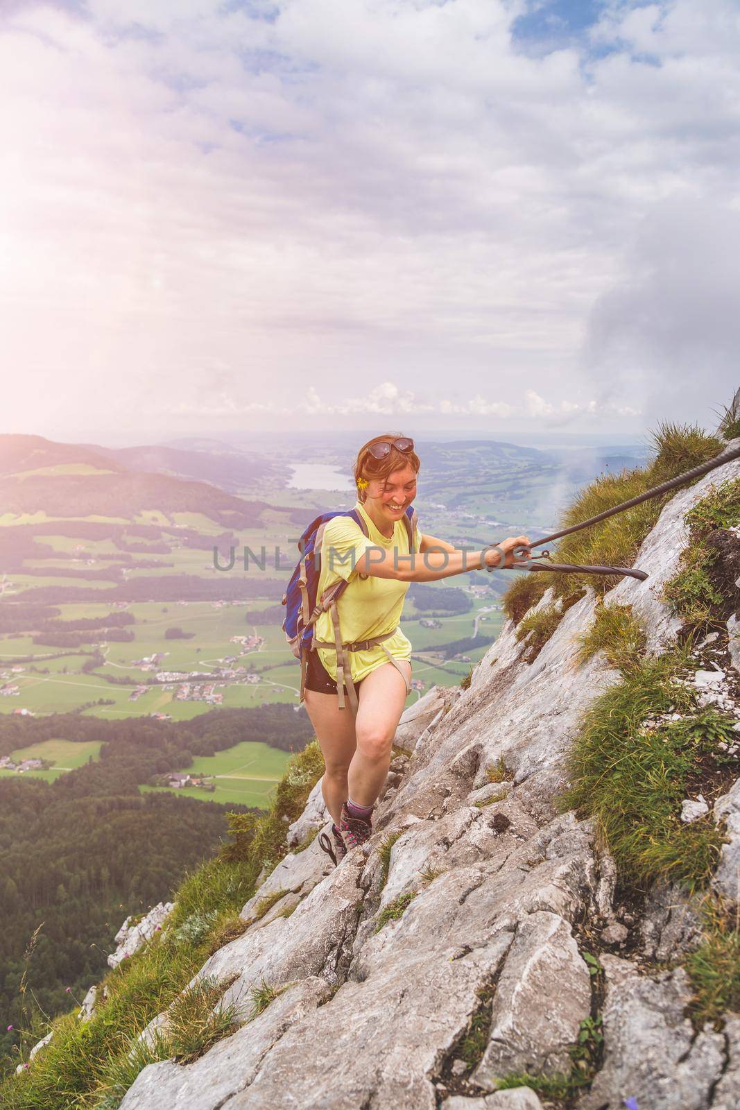 Young slim backpacker tourist girl climbing on rocky mountain, Austria