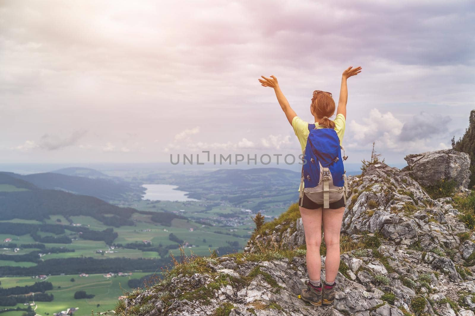 Young slim backpacker tourist girl is enjoying the view on rocky mountain, Austria