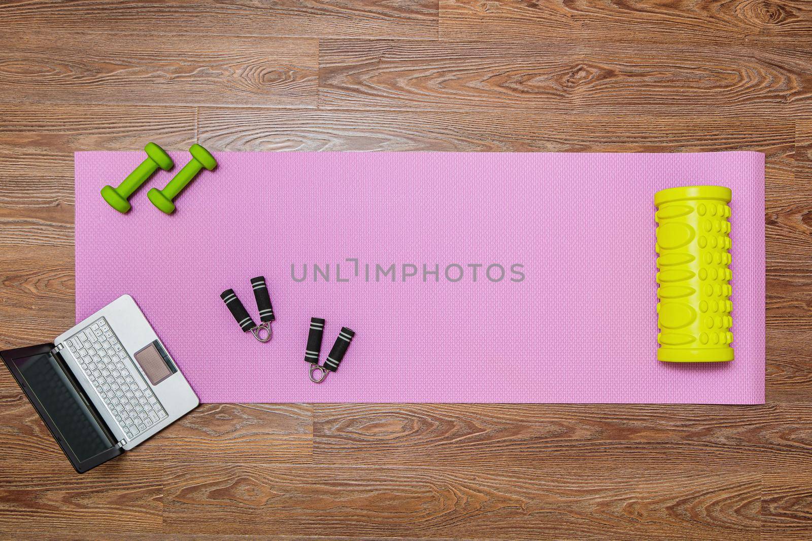 Fitness mat, dumbbells, expander and laptop for online workouts at home. by Yurich32