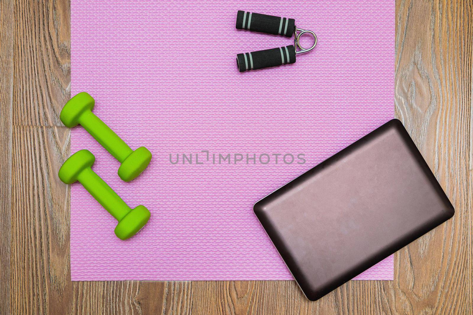 Fitness mat, dumbbells, expander and laptop for online workouts at home. by Yurich32