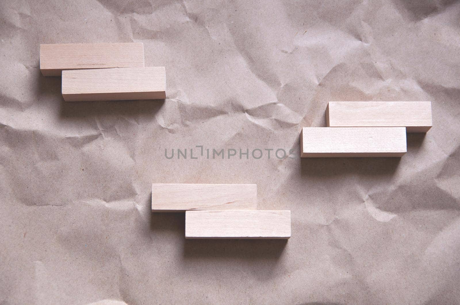 background of crumpled craft paper with wooden rectangles arranged in a certain order by ozornina