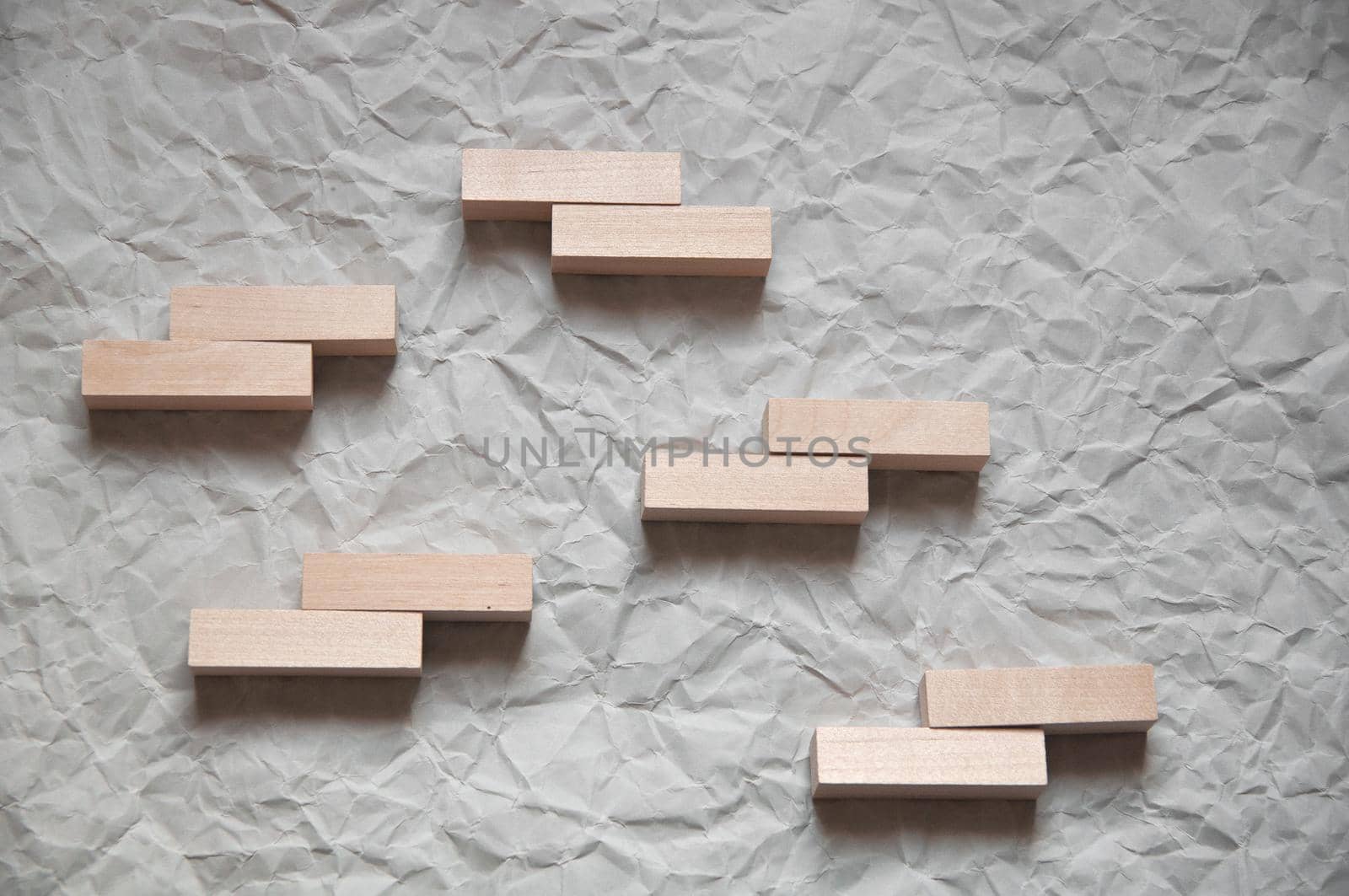background of crumpled craft paper with wooden rectangles arranged in a certain order in a minimalist style