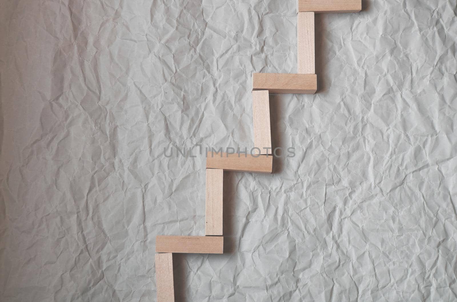 background of crumpled craft paper with wooden rectangles arranged in a certain order in a minimalist style