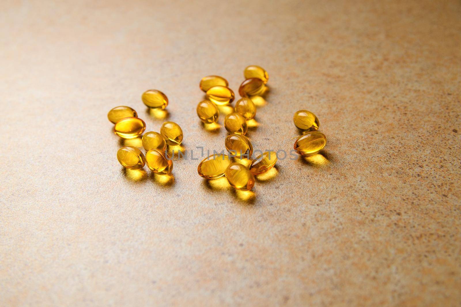 Vitamin D and fish oil capsules randomly lie on the background